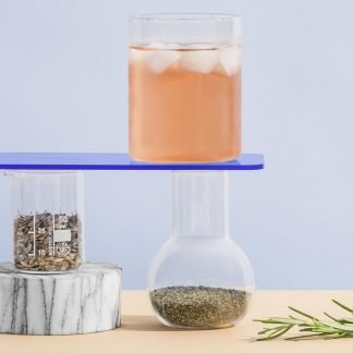 Glass of herbal tea styled with materials and herbs